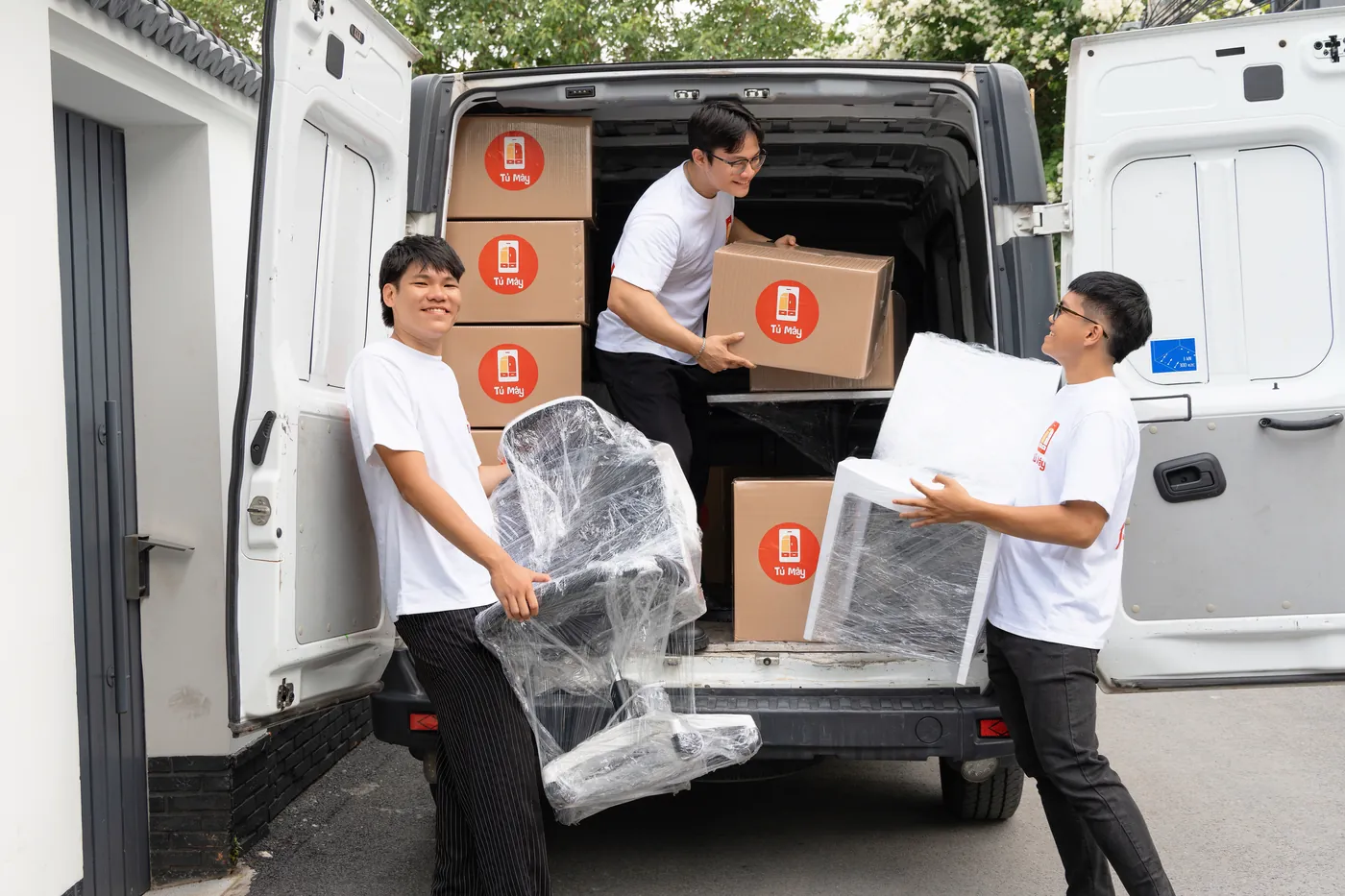 Crew loading wrapped furniture and boxes into the back of the van