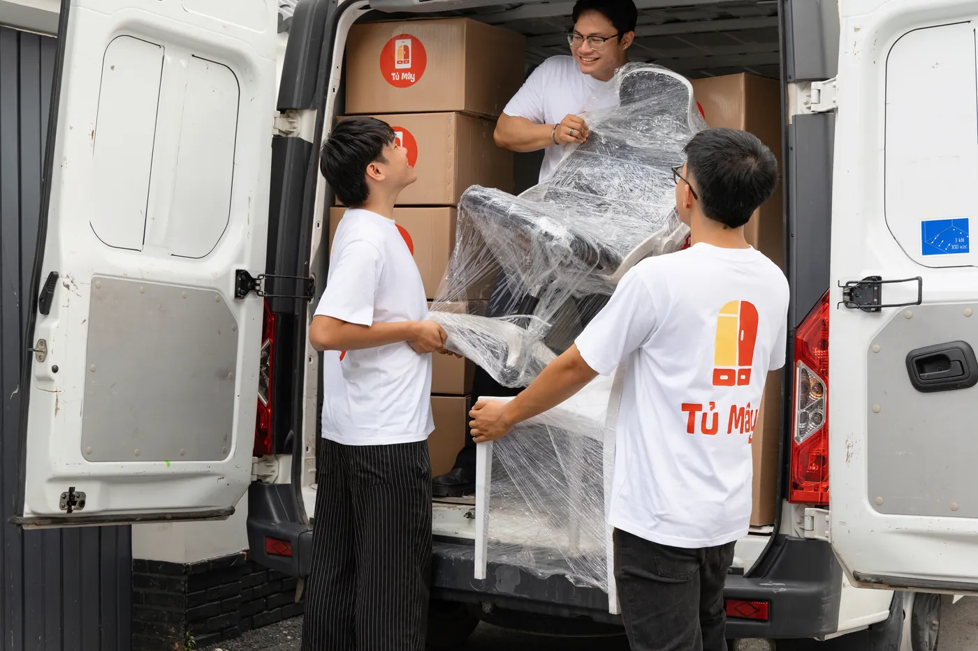 Tủ Mây crew wrapping a chair before loading