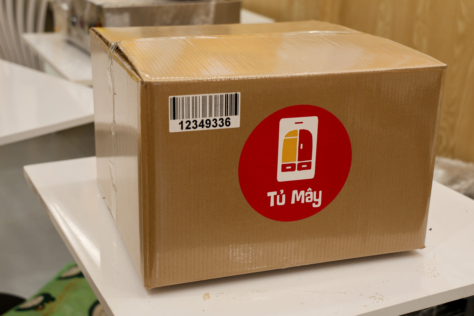 A sealed Tủ Mây box close to camera, carrying its own barcode