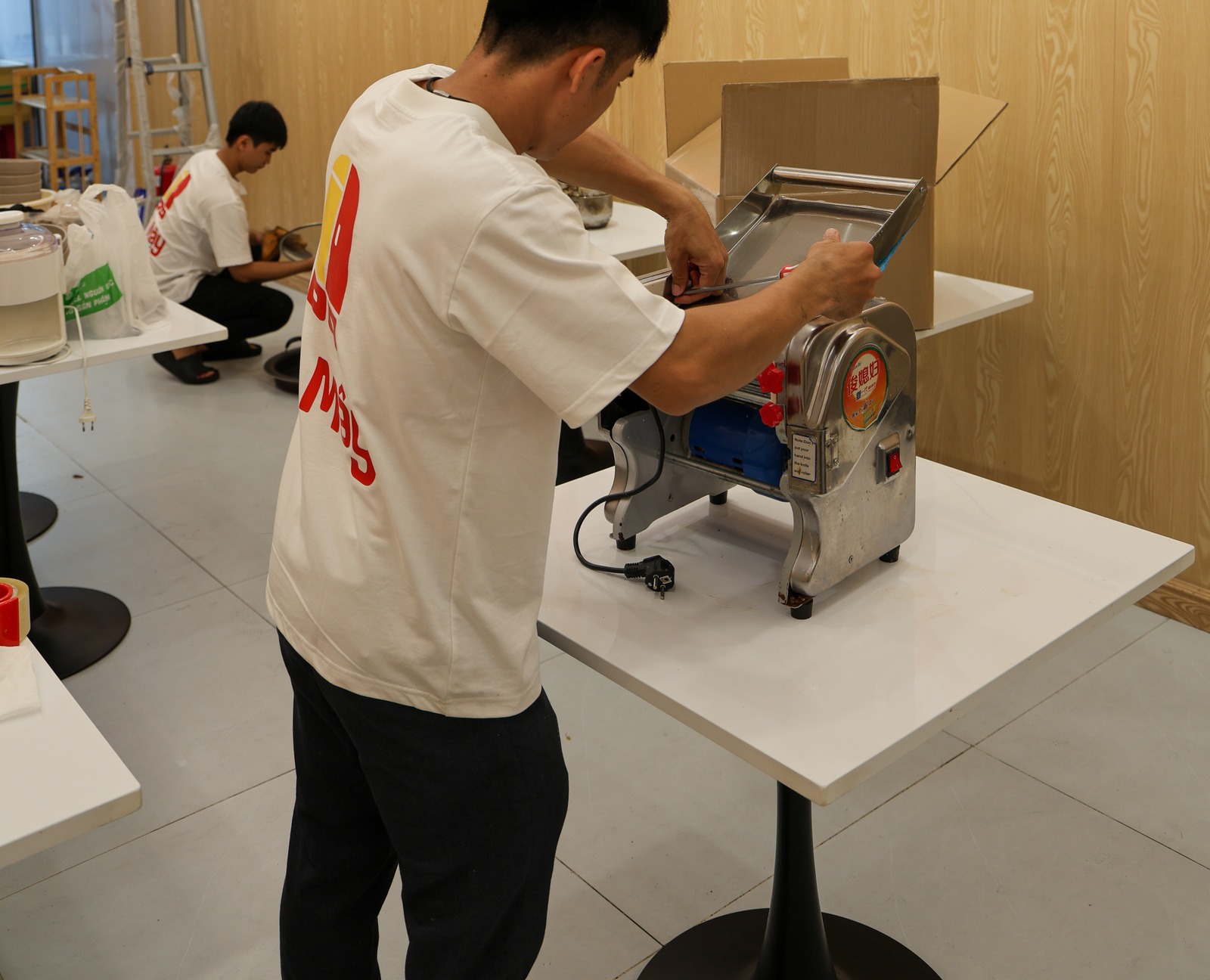 A crew member dismantling the dough sheeter before it is boxed