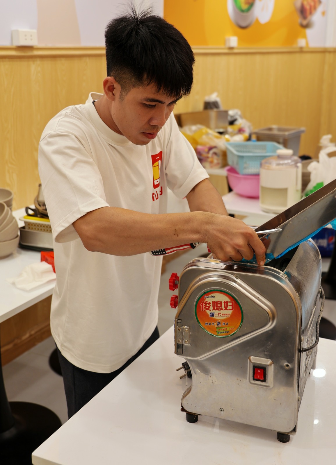 A crew member removing the blade from a dough sheeter before packing