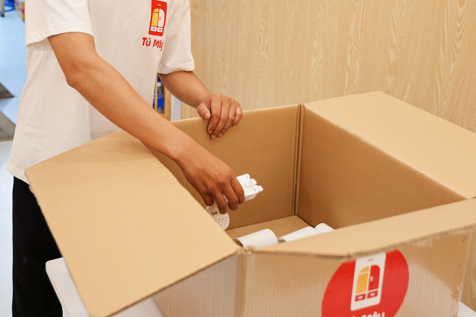 A wrapped item going into a Tủ Mây box, close to camera